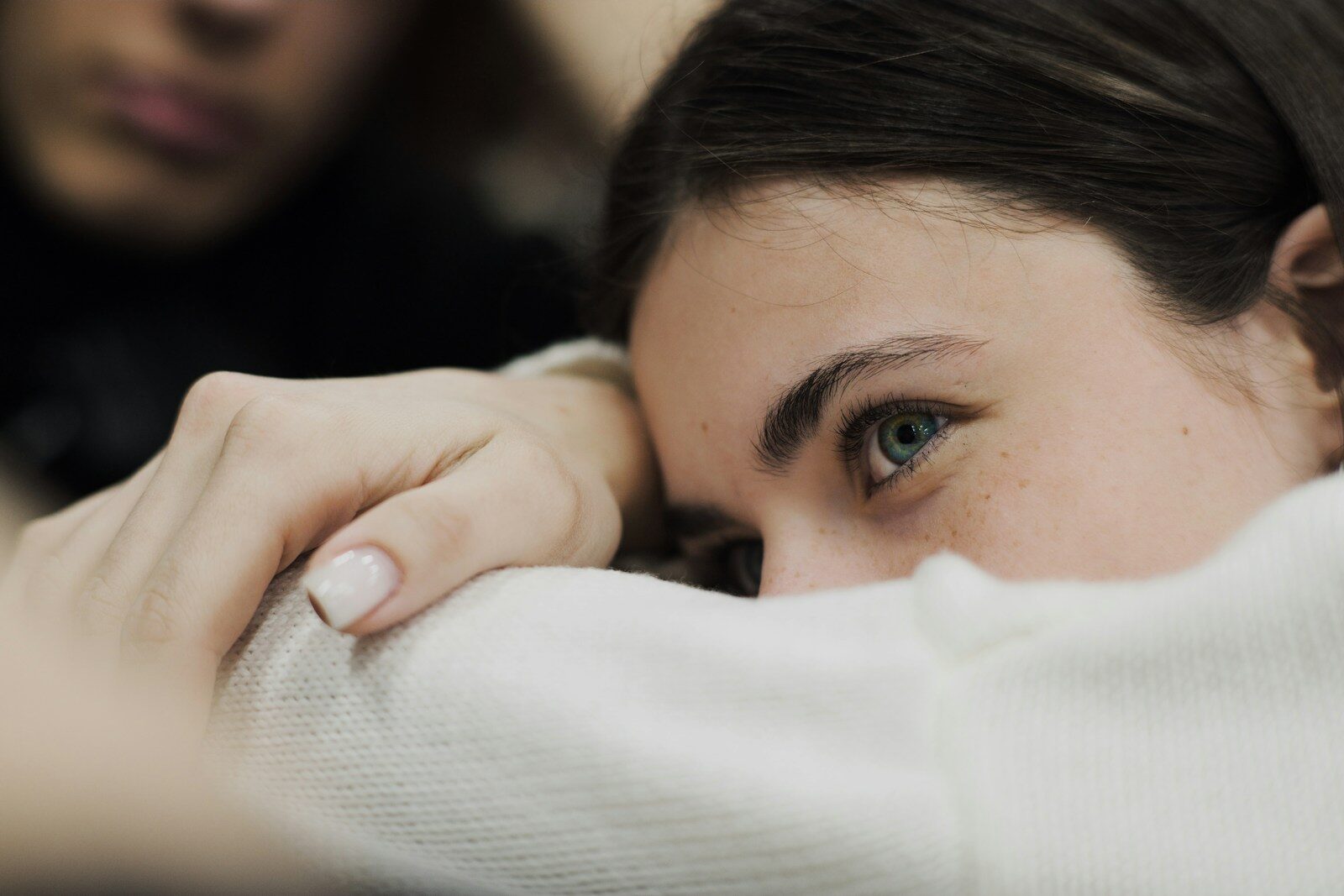 A woman with her hand on her shoulder